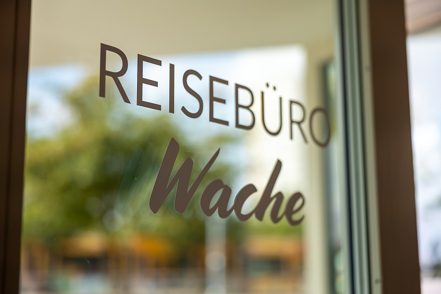 Schriftzug REISEBÜRO Wache in einer sich spiegelnden Tür