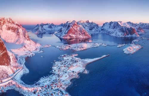 Luftbild auf die verschneiten Lofoten in Norwegen bei Sonnenaufgang