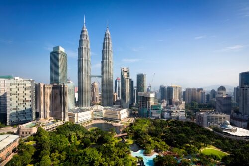 Malaysia-buchen-suedostasien-kuala-lumpur-erfurt-reisebuero-wache Südostasien Urlaub buchen in Erfurt bei REISEBÜRO Wache; im Bild: Patronas Türme von Koala Lumpur, der Hauptstadt von Malaysia, außerdem andere Wolkenkratzer, im Vordergrund ein grüner Park.