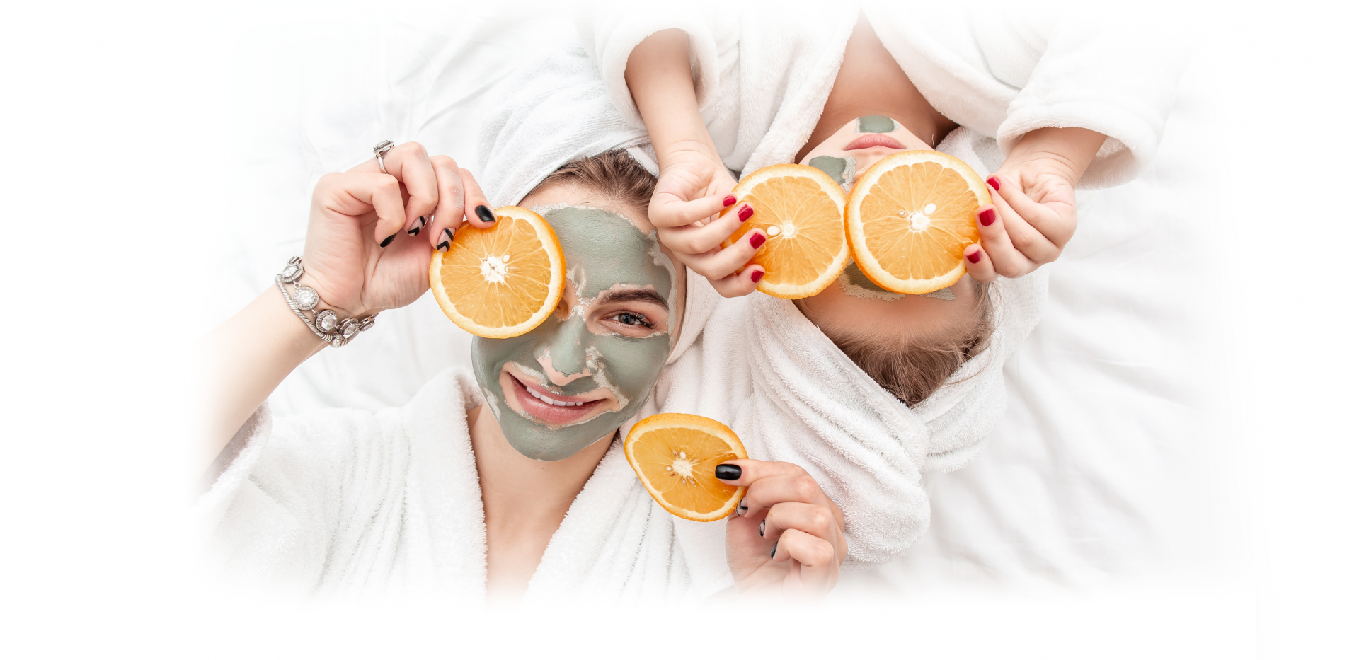 Symbolbild Muttertag: zwei Frauen halten sich Orangenscheiben vor die Gesichter, sie tragen Gesichtsmasken