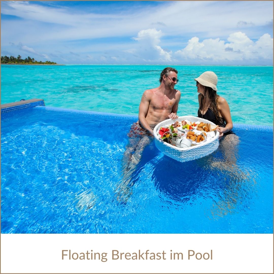 Erfurt REISEBÜRO Wache: Malediven Urlaub buchen; im Bild: Paar im Pool, vor sich ein Tablett mit hohem Rand und Frühstück darauf, sog. floating breakfast. Im Hintergrund das türkisfarbene Meer