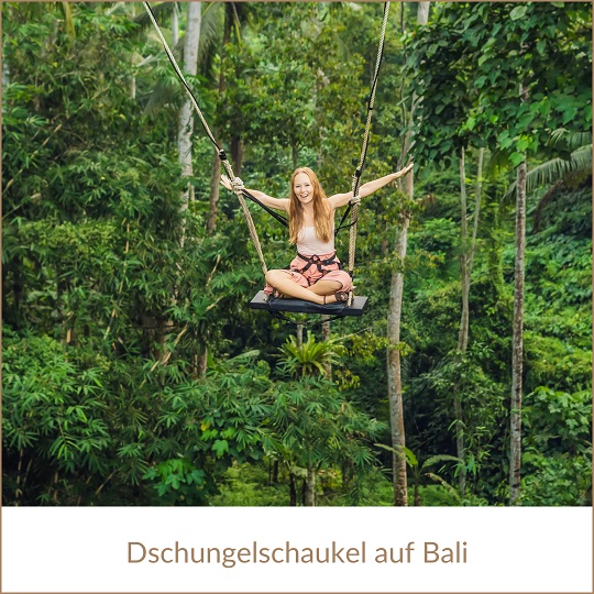 Bali Urlaub bei REISEBÜRO Wache Erfurt; im Bild: Frau auf einer Schaukel, durch Seile gesichert, die hoch zwischen grünen Bäumen schaukelt