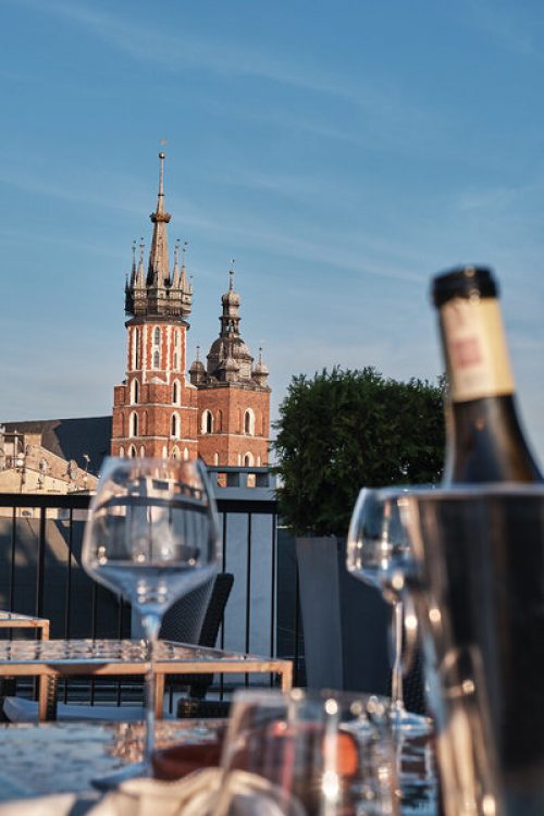 Erfurt Reisebuero Wache Krakau Stary Hotel Rooftop Bar Aussicht Sehenswürdigkeiten Krakau, Polen: Blick auf die Marienkirche am Hauptmarkt, im Vordergrund Tisch und Weingläser, Reisebüro Erfurt