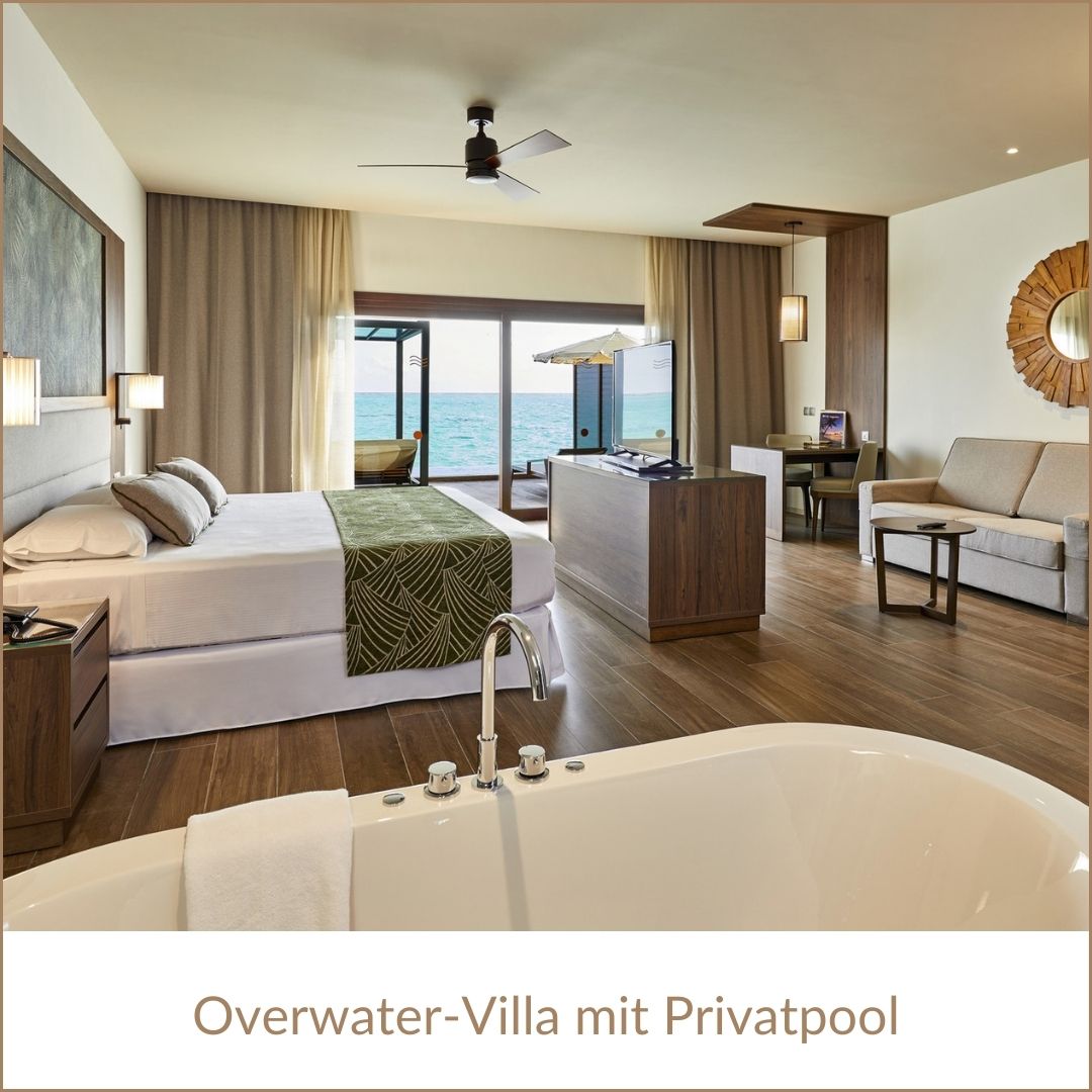 Erfurt REISEBÜRO Wache: Overwater-Bungalow im RUI Palace Maldives, 5-Sterne-Hotel, Malediven, zu sehen: Badewanne Doppelbeet, große Verandafenster, rechterhand: schicker Spiegel über hellen Couch