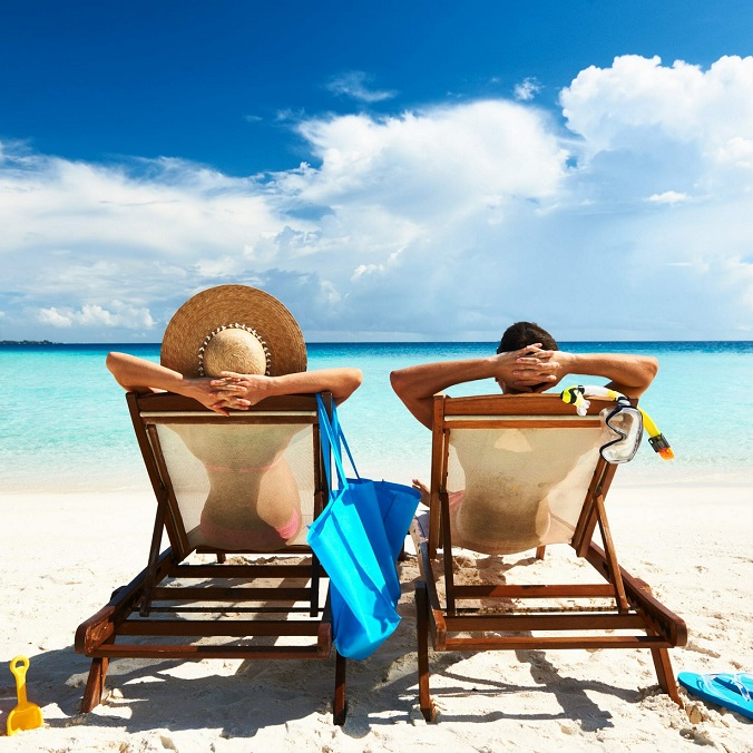 Erfurt REISEBÜRO Wache: Den verdienten Urlaub entspannt planen; Symbolbild: Mann und Frau in Liegestühlen im Sandstrand am Meer