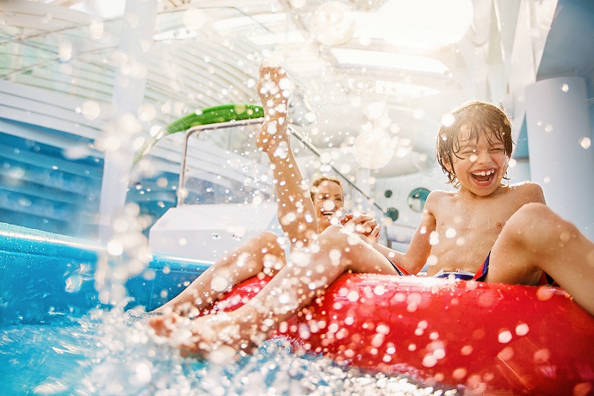 REISEBÜRO Wache Erfurt, AIDA Sommerferien auf der AIDA-Perla: Kind und Mutter mit buntem Reifen auf einer Wasserrutsche