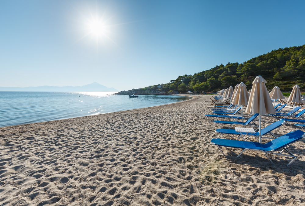 Ein Sonnenaufgang am Strand von Chalkidiki, Halbinsel in Griechenland; am menschenleeren Strand Sonnenliegen