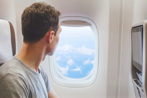 Erfurt REISEBÜRO Wache, Online Check- In Flug; Symbolbild zeigt: einen Mann, der aus dem Flugzeugfenster schaut