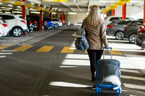 Frau mit Tasche und Koffer in einem Parkhaus: Symbolbild für Online buchen