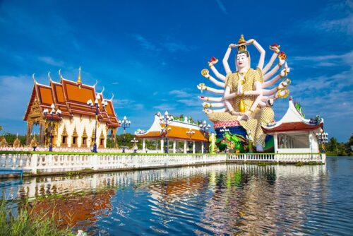 thailand-urlaub-buchen-erfurt-reisebuero-wache-wat-plai-laem Thailand Urlaub buchen Erfurt; im Bild: der Tempel Wat Plai Laem auf Koh Samui, eine riesige 18-armige Buddha-Statue umgeben von Tempel-Häusern mit Dächern, die leicht nach oben gebogen auslaufen